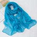 Close-up of bright blue chiffon scarf texture with delicate edges and soft pleats - Teal