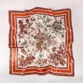 Detail of green and orange butterfly floral print satin silk square scarf showing texture - Orange