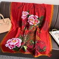 Detail of red silk scarf with peony patterns on a leather sofa with accessories - One Size / Red