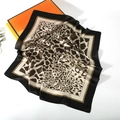 Detail of leopard print silk satin square scarf with black border next to orange box - Black Brown Floral Leopard