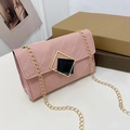 Pink quilted crossbody bag featuring a geometric gold-trimmed lock and gold chain strap - Pink