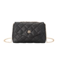 Detail of black quilted shoulder bag featuring a gold rose-shaped metal twist lock closure - Black
