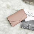 Dusty pink envelope wallet with litchi texture and fur ball detail on plush background - Pink