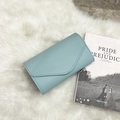 Light blue faux leather long wallet with curved envelope flap on soft faux fur background - Blue