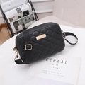 Elegant black quilted shoulder bag with gold hardware and wide strap on white magazine - Black