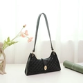 Minimalist black baguette bag with embossed polka dot texture and gold twist clasp - Black