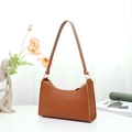 Elegant brown leather baguette underarm bag with gold rings on white minimalist background - Brown