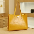 Borsa tote gialla alla moda con stampa coccodrillo e manici lunghi in una boutique - Giallo (Motivo Coccodrillo)