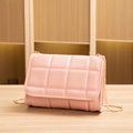 Pink quilted flap shoulder bag with gold chain strap on wooden surface - Pink