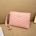 Detail of pink quilted envelope clutch featuring V-pattern stitching and gold hardware - Pink