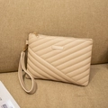 Close-up of beige quilted envelope clutch with metallic accent and wrist strap detail - Apricot