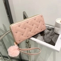 Pink heart-embroidered long wallet with plush ball charm and wristlet on a marble table - Pink