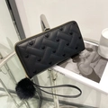 Black long faux leather wallet with woven heart patterns and fluffy ball charm accessory - Black