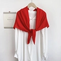 Detail of a bright red scarf knotted over a white collared shirt on a wooden hanger - Red