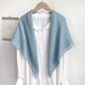 Detail of light blue minimalist scarf draped over a white shirt on a wooden hanger - Light Blue