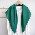 Close-up of lightweight dark green scarf draped over a white shirt on wooden hanger - Green