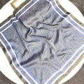 Sky blue satin square scarf with golden horsebit chain print on a white table - Sky Blue