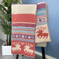 Détail d'une écharpe de Noël en maille avec motifs rennes et cœurs sur une chaise - Rose Poudré