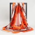 Foulard in raso arancione e bianco con motivi a catena equestre su espositore nero - Arancione