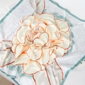 Dettaglio di foulard in seta con stampa floreale arancione, bordo verde menta e drappeggio - 90cmx90cm / Verde Fresco