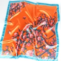 Close-up of glossy orange satin silk scarf featuring pink floral patterns and blue borders - 90*90cm / Orange