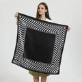 Detail view of 90cm black and white polka dot satin square scarf held by a model - Polka Dot Empty Center