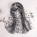 Vue détaillée d'une écharpe légère en georgette avec motif léopard noir et blanc - Noir