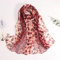 Détail d'un foulard d'été léopard montrant la texture légère en georgette et l'ourlet - Bordeaux