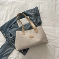 Minimalistische beige Canvas-Einkaufstasche mit hellbraunen Ledergriffen auf Denim - Khaki