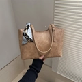 Braune Tragetasche mit Seidenschal-Detail und goldener Hardware in natürlichem Licht - Khaki