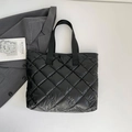 Sac fourre-tout noir matelassé avec surpiqûres losanges et anses sur un fond minimaliste - Noir