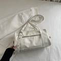 Minimalist cream white pillow bag with silver buckle strap on corduroy jacket background - White