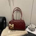 Deep red quilted rhombus tote bag with plush charm and double handles on a cozy surface - Red