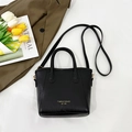 Bolso tipo cubo de cuero negro mate con letras doradas y correa ajustable fina - Negro