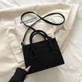 Black leopard texture crossbody bag with gold hardware on a stylish beige blazer - Black