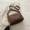 Borsa tote marrone con stampa leopardata e tracolla su uno sfondo di blazer bianco - Leopardo Caffè