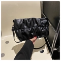 Macro view of black pleated handbag texture with silver metal hardware and soft leather - Black