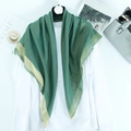 Detailed view of dark green scarf with golden lurex thread and wide metallic edge finish - Green