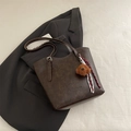 Borsa tote marrone scuro con ciondolo a forma di orso su sfondo di abito elegante - Con Ciondolo / Marrone