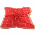 Detailed view of red and gold checkered cotton scarf with silk thread accents - Red