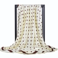 Détail d'un foulard carré en satin à pois rétro avec une bordure contrastée - Crème