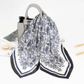 Elegant 70cm square silk scarf with blue paisley print draped over a grey handbag - Black