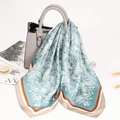Lake blue paisley silk scarf tied on a luxury handbag as a stylish accessory - Cyan