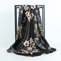 Elegant 90x90cm satin silk scarf with black floral print draped on a metal frame - Black