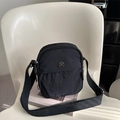 Bolso bandolera negro ligero de nailon con correa ancha sobre silla blanca - Negro