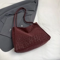 Minimalist burgundy leopard print tote bag with shoulder strap on a grey blazer jacket - Red