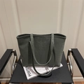 Dark green leopard print tote bag placed on a vintage leather chair with magazines - Green