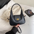 Large black woven crescent shoulder bag with gold clasp shown in a lifestyle bedroom setting - Black