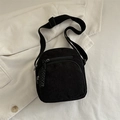 Black corduroy crossbody bag with adjustable strap and textured zipper detail - Black