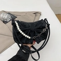 Black pleated handbag with elegant bow design and decorative white pearl chain - Black